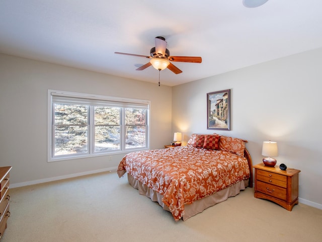 bedroom featuring light carpet, baseboards, and a ceiling fan