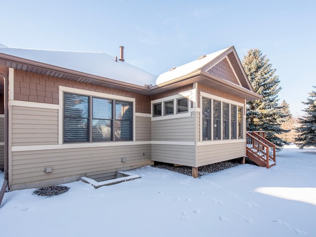 view of snow covered rear of property