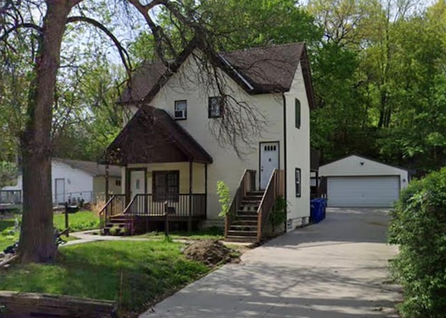 view of front facade featuring a garage, a front lawn, an outdoor structure, and stucco siding