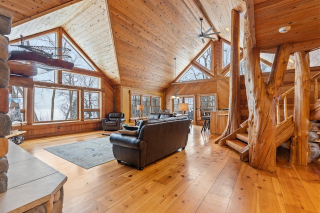 living room featuring wood ceiling, wood walls, high vaulted ceiling, and a healthy amount of sunlight