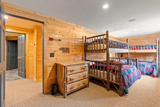 bedroom with recessed lighting, carpet floors, and wood walls