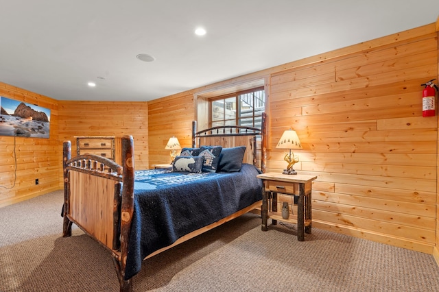 carpeted bedroom with recessed lighting and wooden walls