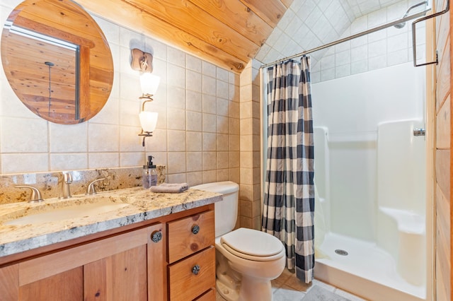 bathroom featuring tile patterned floors, a stall shower, vanity, tile walls, and toilet