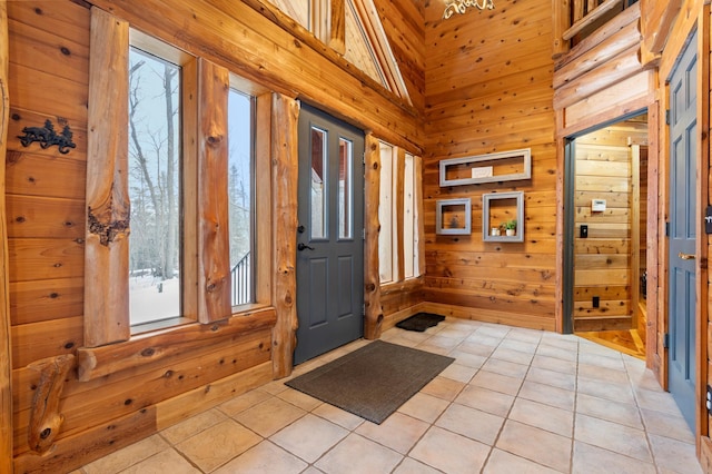 entrance foyer with wooden walls and light tile patterned floors