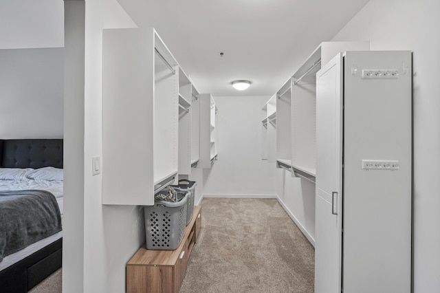 walk in closet with light colored carpet