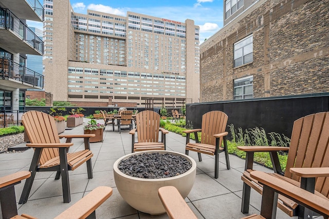 view of patio featuring an outdoor fire pit and a city view