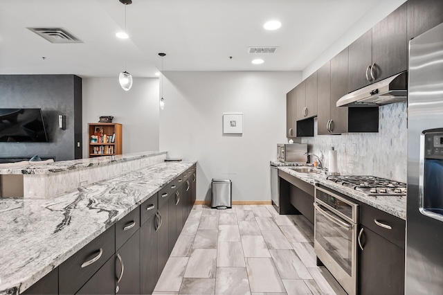 kitchen with pendant lighting, appliances with stainless steel finishes, visible vents, and under cabinet range hood