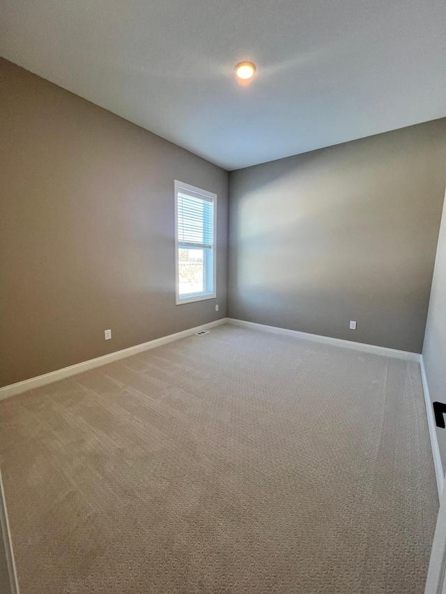 spare room with carpet and baseboards