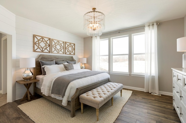 bedroom featuring dark wood-style floors, baseboards, and an inviting chandelier