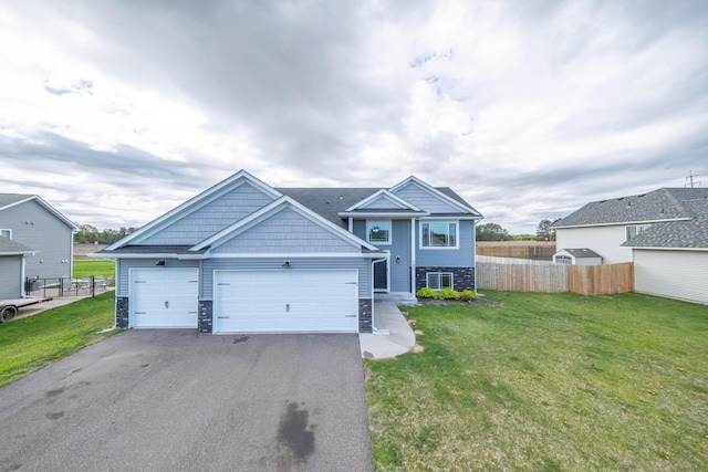 view of front of house featuring stone siding, aphalt driveway, a front yard, and fence