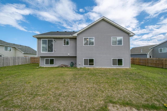 back of house featuring a fenced backyard and a yard