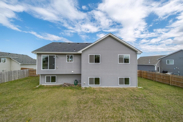 back of property featuring a fenced backyard and a yard