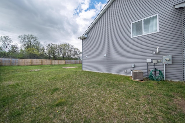 view of yard with a fenced backyard and central AC unit