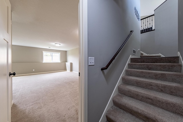 stairs featuring carpet and baseboards