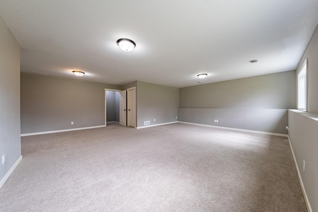 empty room featuring carpet flooring and baseboards