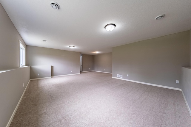 carpeted spare room featuring baseboards and visible vents