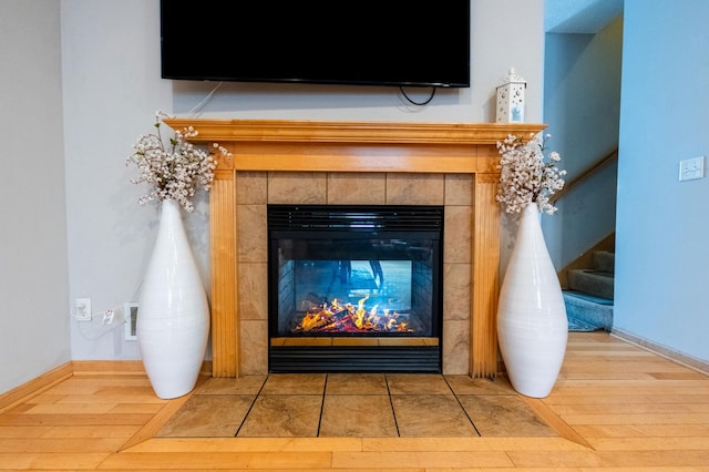 interior details with visible vents, a fireplace, baseboards, and wood finished floors