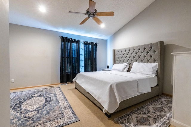 carpeted bedroom with ceiling fan, baseboards, vaulted ceiling, and a textured ceiling