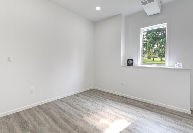 unfurnished room featuring light wood-style flooring, baseboards, and recessed lighting