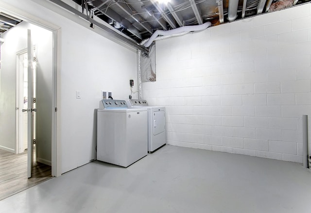 laundry room featuring concrete block wall, laundry area, and washer and dryer