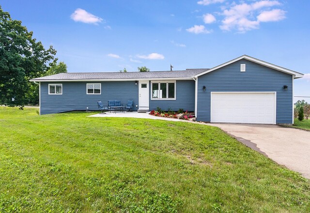 ranch-style home featuring a front lawn, concrete driveway, and an attached garage