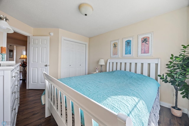 bedroom with a closet, baseboards, and dark wood-style flooring