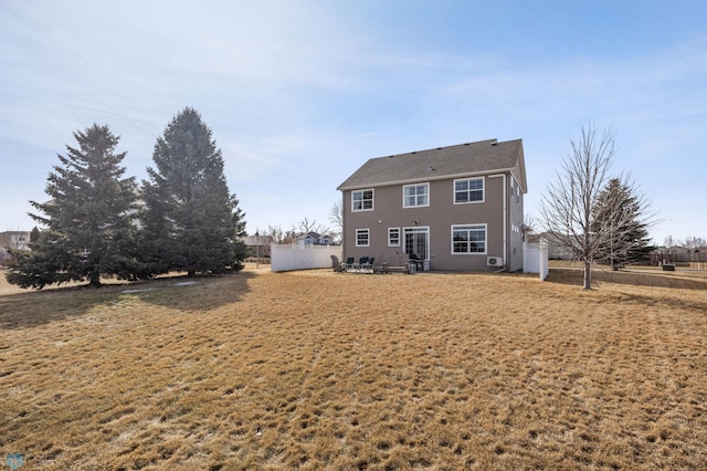 rear view of property with a yard and fence