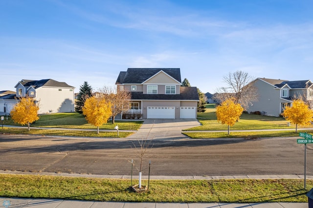 traditional-style house with a garage, concrete driveway, and a front lawn