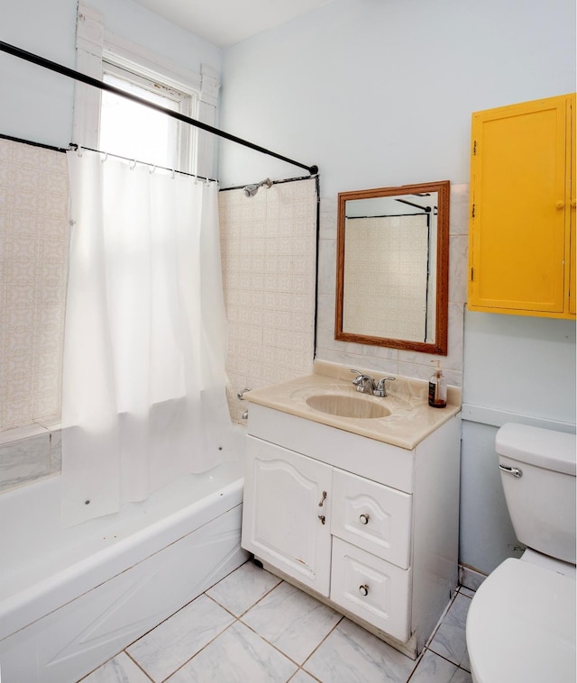 full bath featuring toilet, marble finish floor, shower / bath combo, and vanity