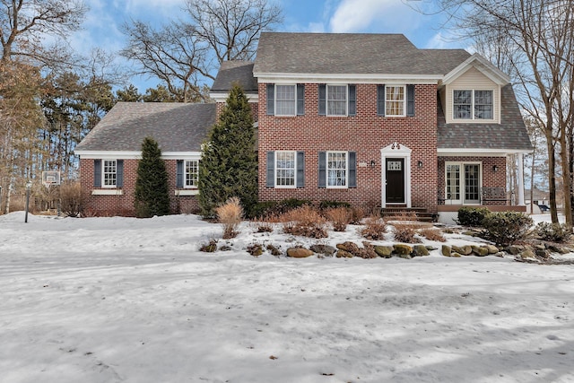 view of front facade featuring brick siding and a shingled roof