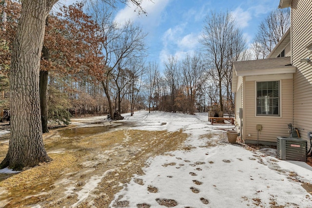 yard covered in snow featuring cooling unit