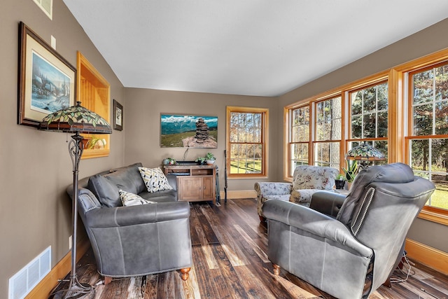 living area with dark wood-style floors, visible vents, and baseboards