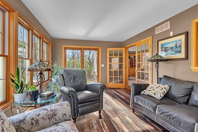 living room featuring french doors, visible vents, and wood finished floors