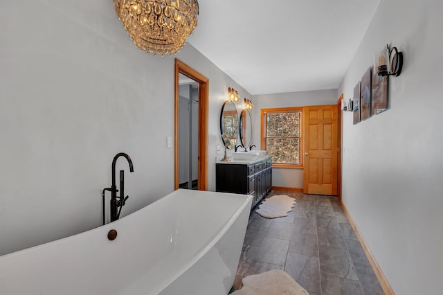 washroom featuring a sink, baseboards, and an inviting chandelier