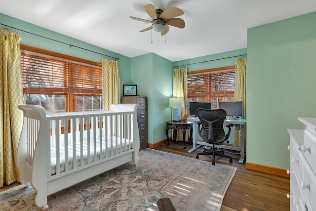 bedroom with ceiling fan, baseboards, and wood finished floors