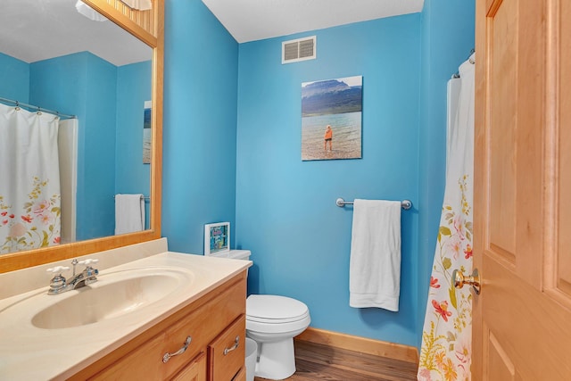 bathroom with baseboards, visible vents, toilet, wood finished floors, and vanity