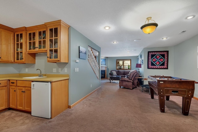 interior space featuring dishwasher, glass insert cabinets, open floor plan, light countertops, and a sink