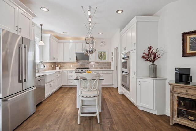 kitchen featuring stainless steel appliances, a sink, white cabinets, and recessed lighting