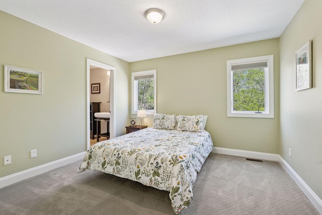 bedroom with carpet, baseboards, and connected bathroom