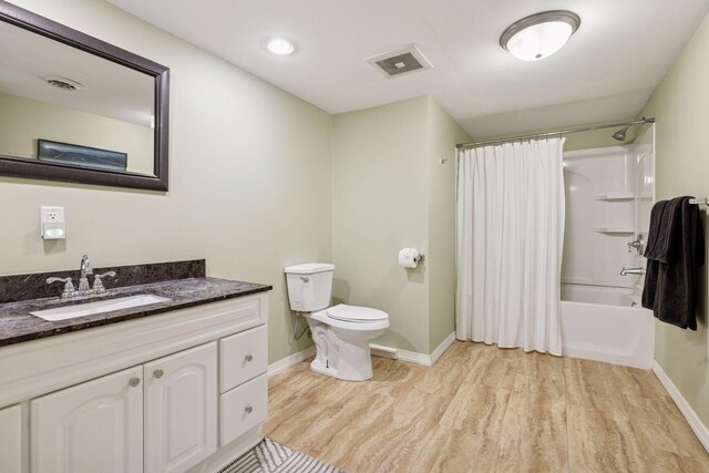 bathroom with baseboards, wood finished floors, toilet, and vanity
