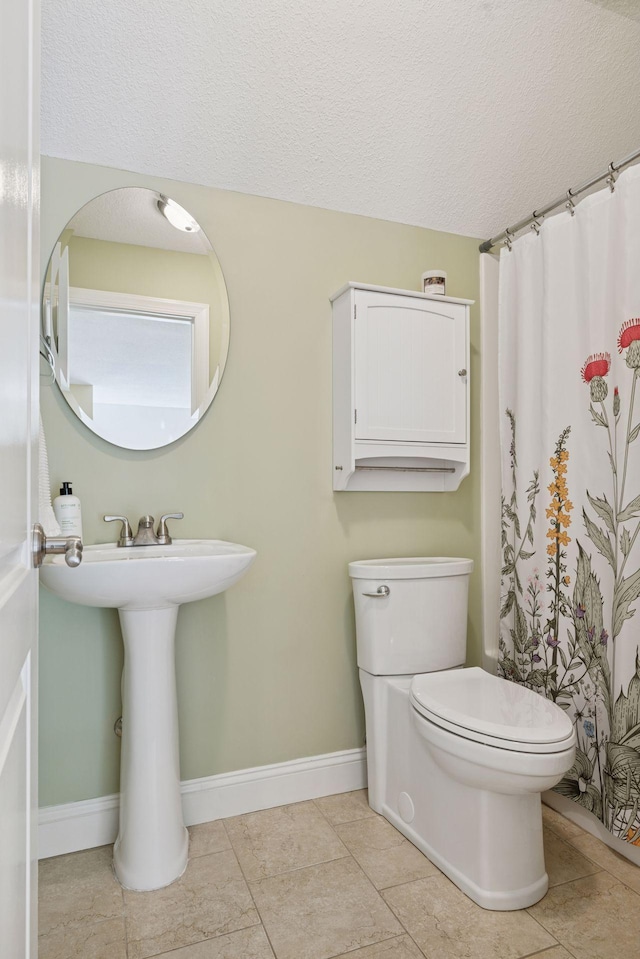 full bathroom with toilet, baseboards, tile patterned floors, a textured ceiling, and a shower with curtain