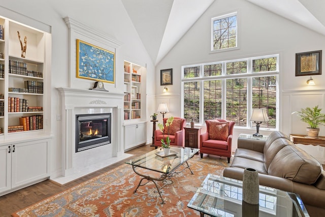 1067 Pioneer Rd, Red Wing, MN 55066 - living room featuring built in features, a decorative wall, a fireplace with flush hearth, wood finished floors, and wainscoting