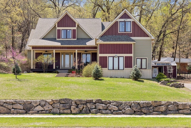 1067 Pioneer Rd, Red Wing, MN 55066 - craftsman-style house featuring a shingled roof, ceiling fan, covered porch, a front yard, and board and batten siding