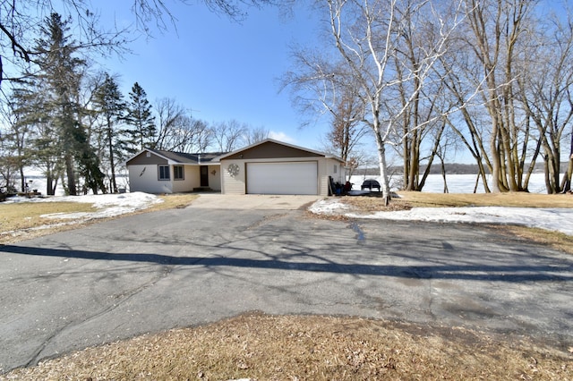 view of front facade with a garage and aphalt driveway