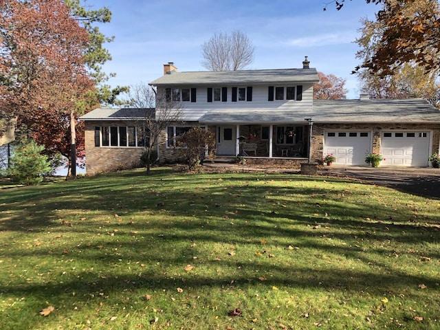 traditional home with a garage, driveway, a chimney, and a front lawn