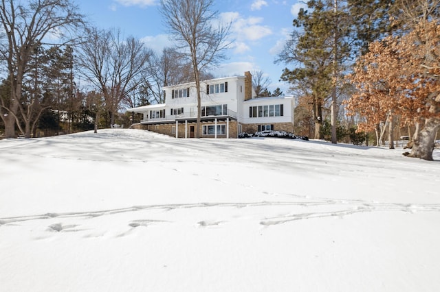 snow covered house with stone siding