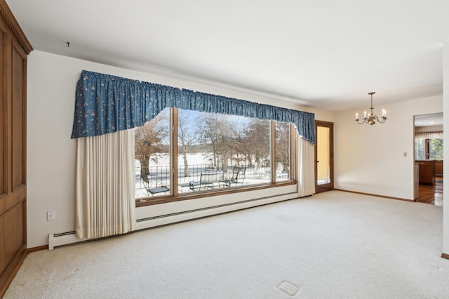 spare room with carpet floors, an inviting chandelier, a baseboard radiator, and baseboards