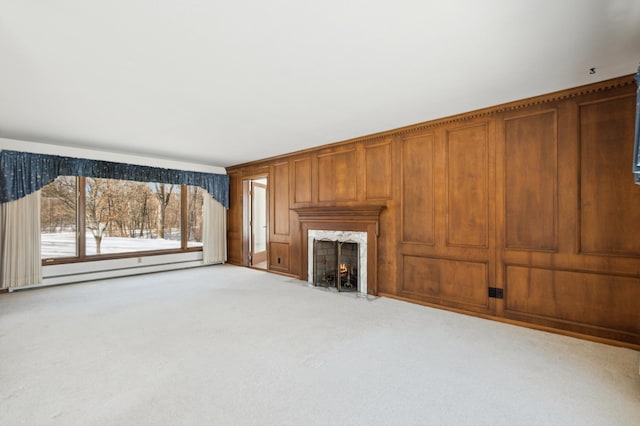 unfurnished living room featuring a baseboard heating unit, a high end fireplace, and carpet flooring