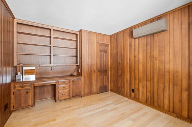 office space featuring wooden walls, a wall unit AC, and light wood-style flooring