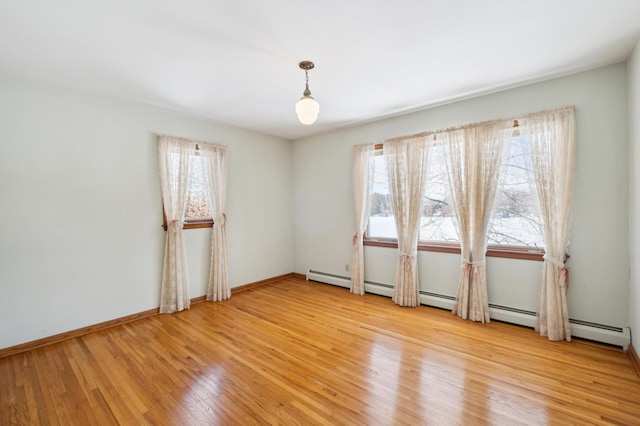 spare room featuring a healthy amount of sunlight, light wood-style flooring, and baseboards